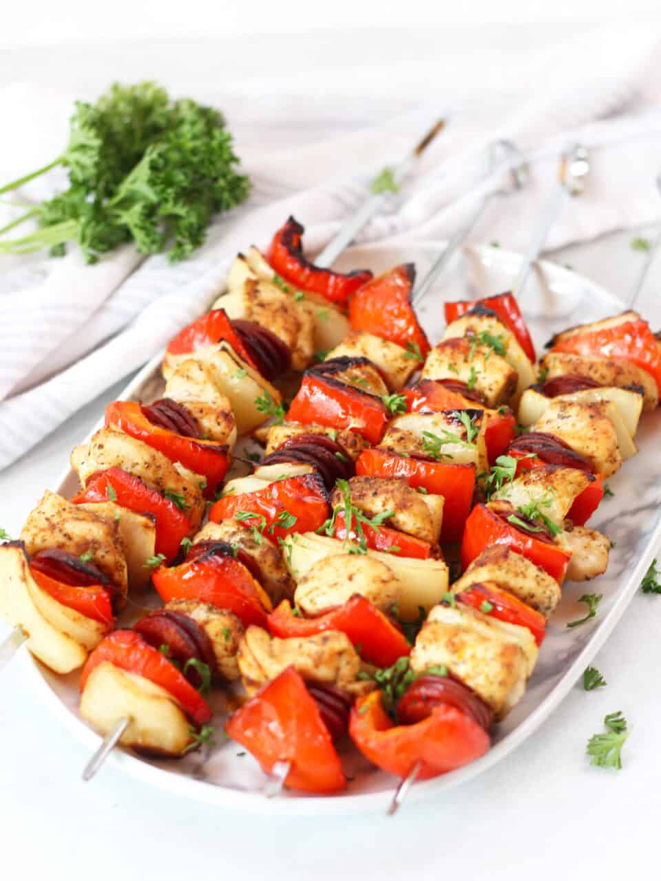 Four chicken chorizo skewers on a serving plate.