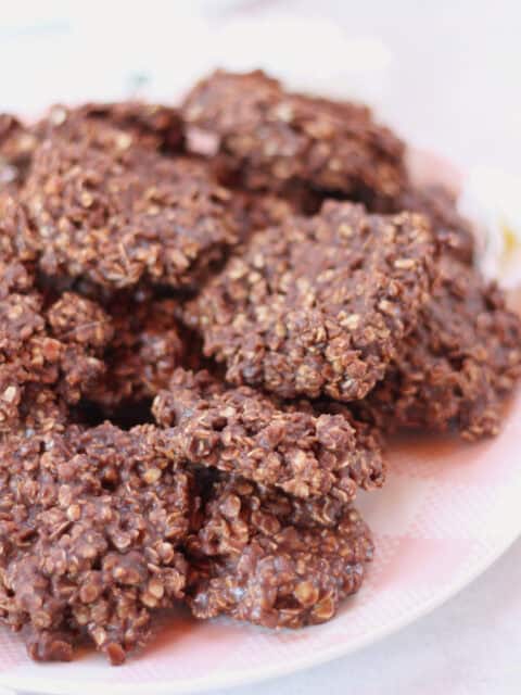 Chocolate oat cookies on a pink and white plate.