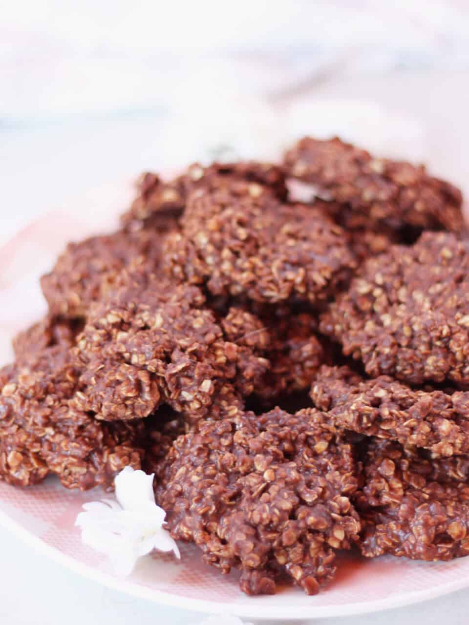 No bake cookies piled on a pink and white plate.
