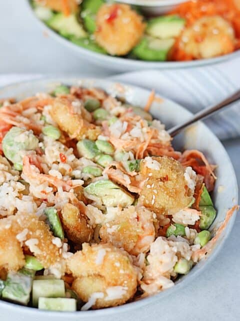 Breaded shrimp with rice, avocados and vegetables.