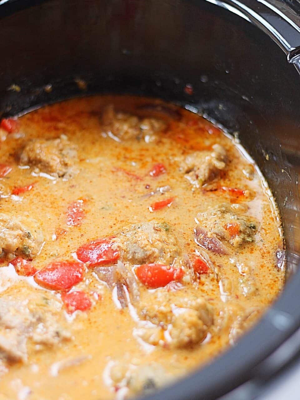 Meatballs in Thai red curry sauce in a Crockpot.