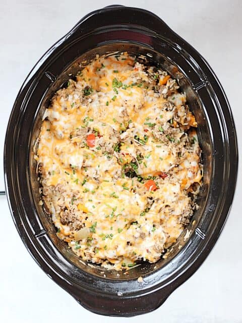 Cooked ground beef and rice casserole in a slow cooker.