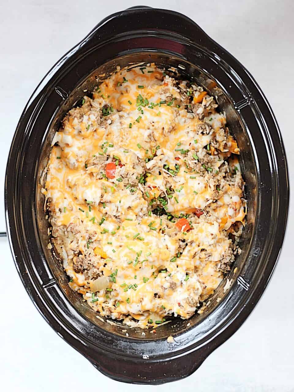 Cooked ground beef and rice casserole in a slow cooker.