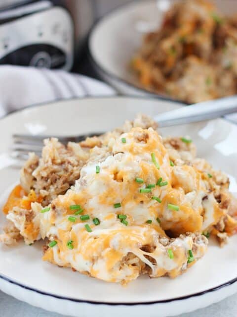 Slow cooker ground beef, rice and cheese casserole served on a plate with a fork.
