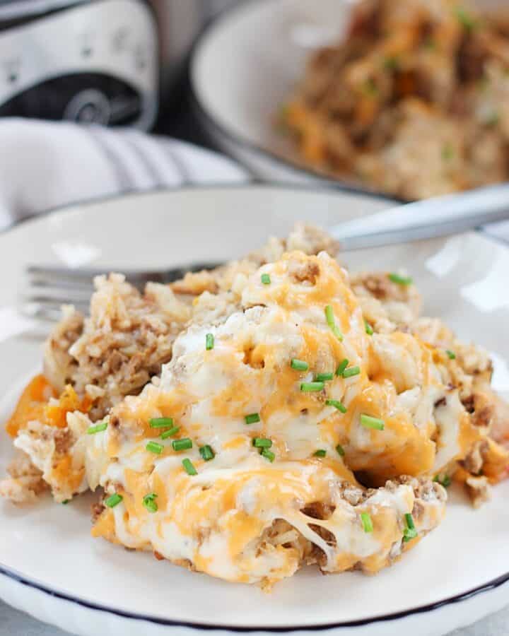 Slow cooker ground beef, rice and cheese casserole served on a plate with a fork.