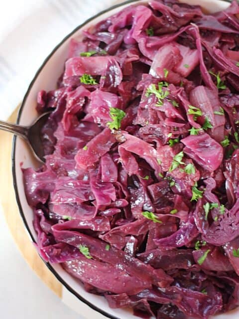 Cooked red cabbage served with fresh parsley garnish.