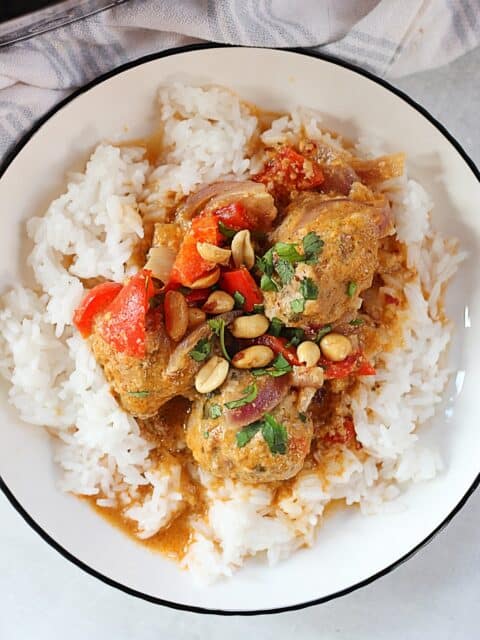 Thai meatballs served on rice with peanuts and fresh cilantro garnish.